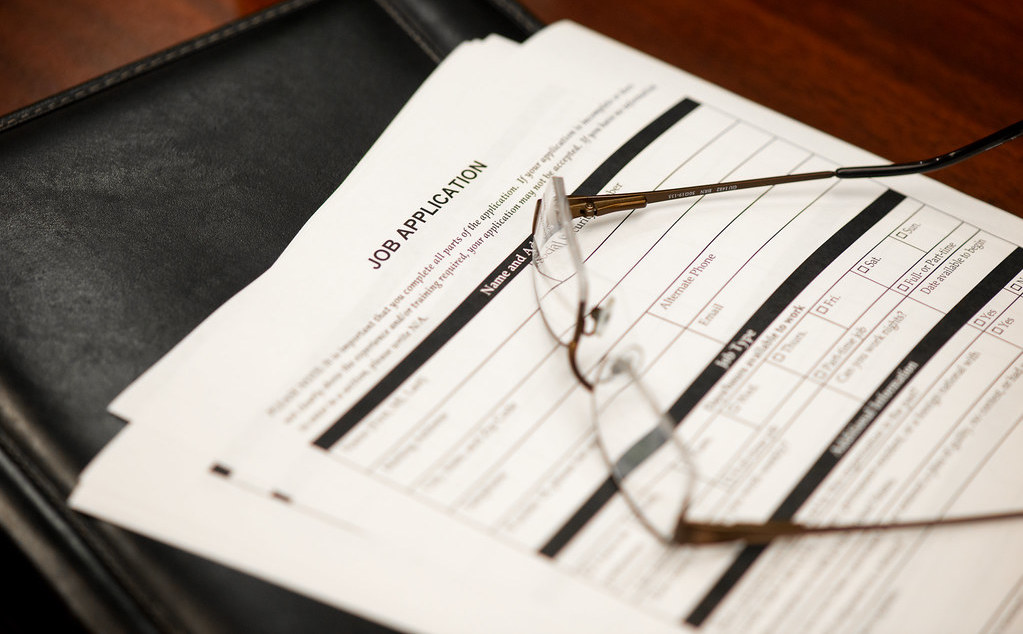 A pair of glasses sit on top of a paper job application.