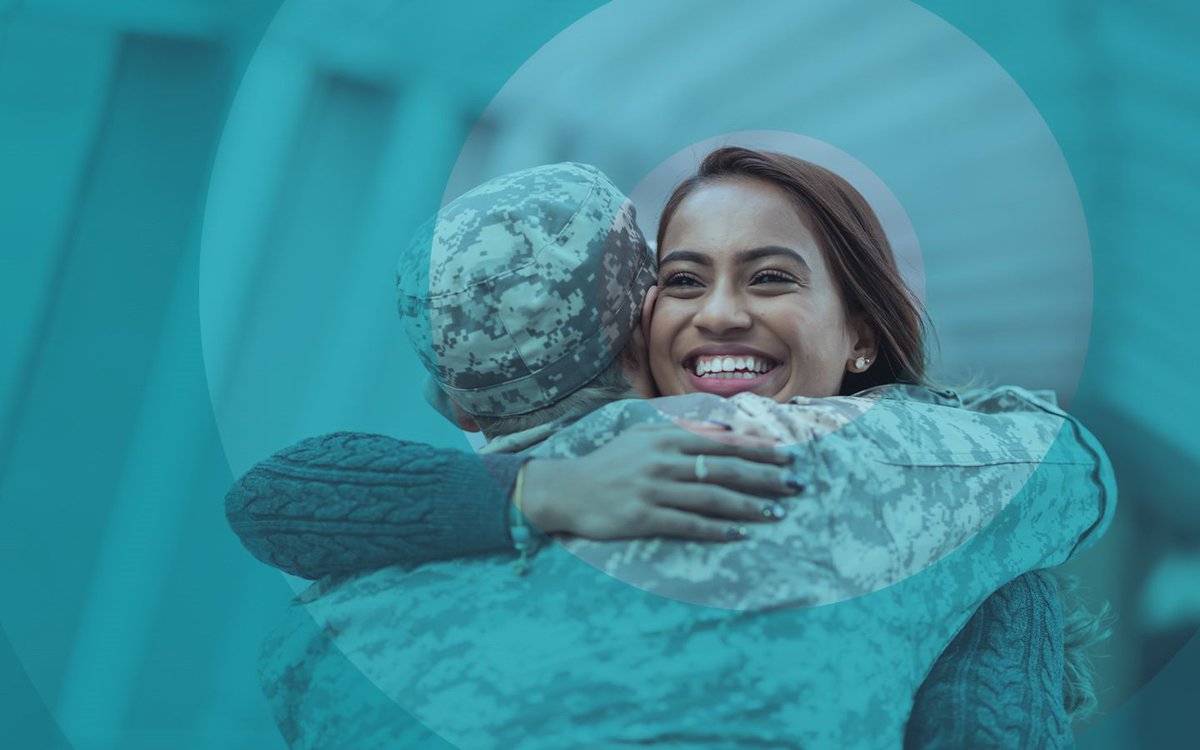 A woman hugs another person in a military uniform.