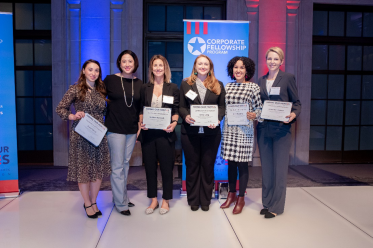 Six women, five of whom are holding certificates, stand facing the camera.