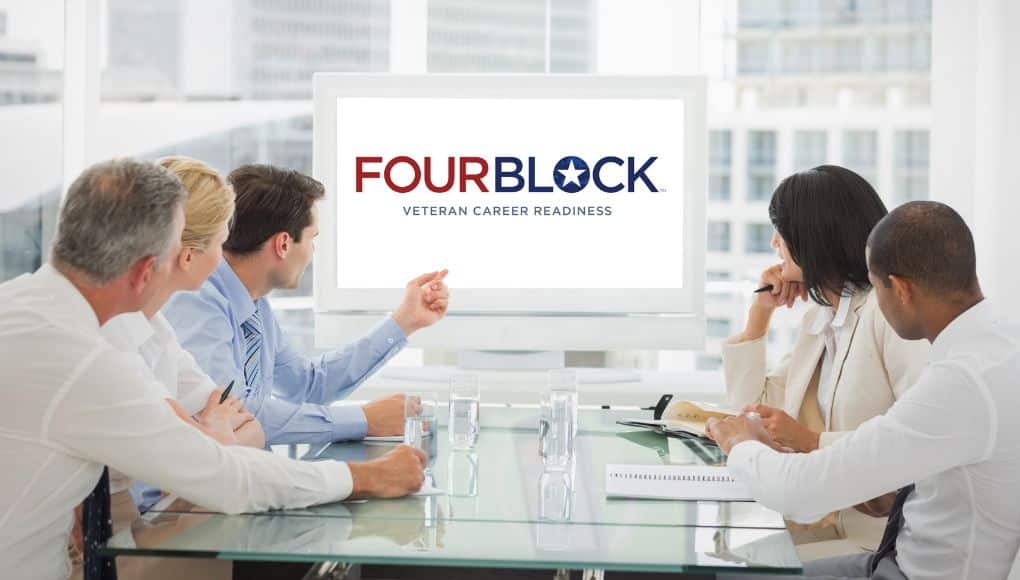 Five people sit around a glass table facing a screen that says "FourBlock".